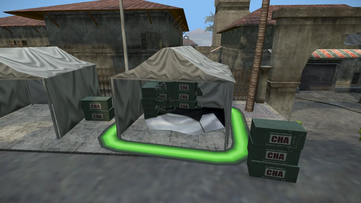A supply tent ringed by a glowing green bomb site marker, with crates and a soldier beside it